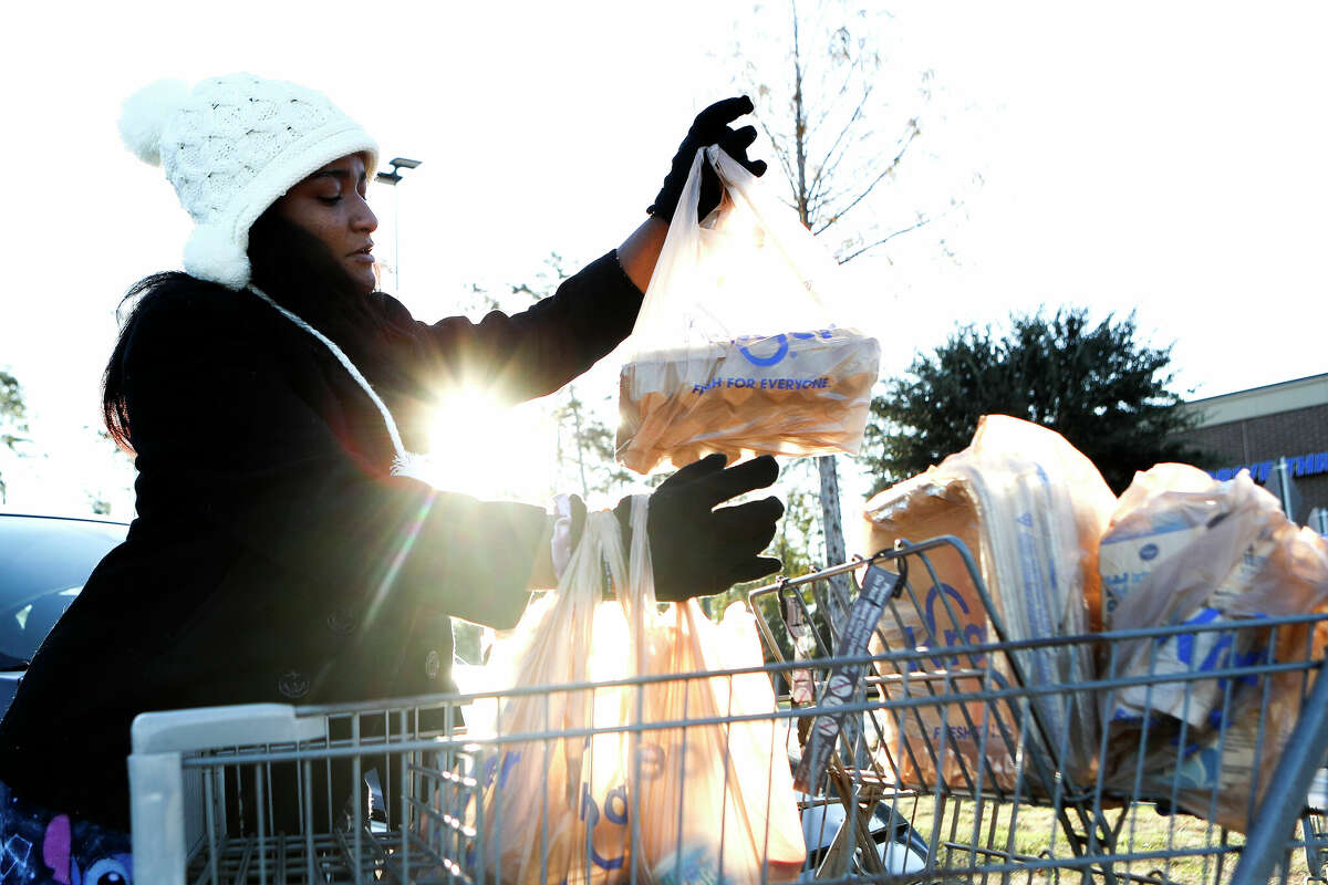 Brandi Forbes quickly gathers groceries for a Christmas party in 14-degree, windy weather, Friday, Dec. 23, 2022, in Conroe. “I thought I left this kind of weather when I moved from Chicago,” Forbes said. “Good thing I didn’t toss all my warm clothes.”