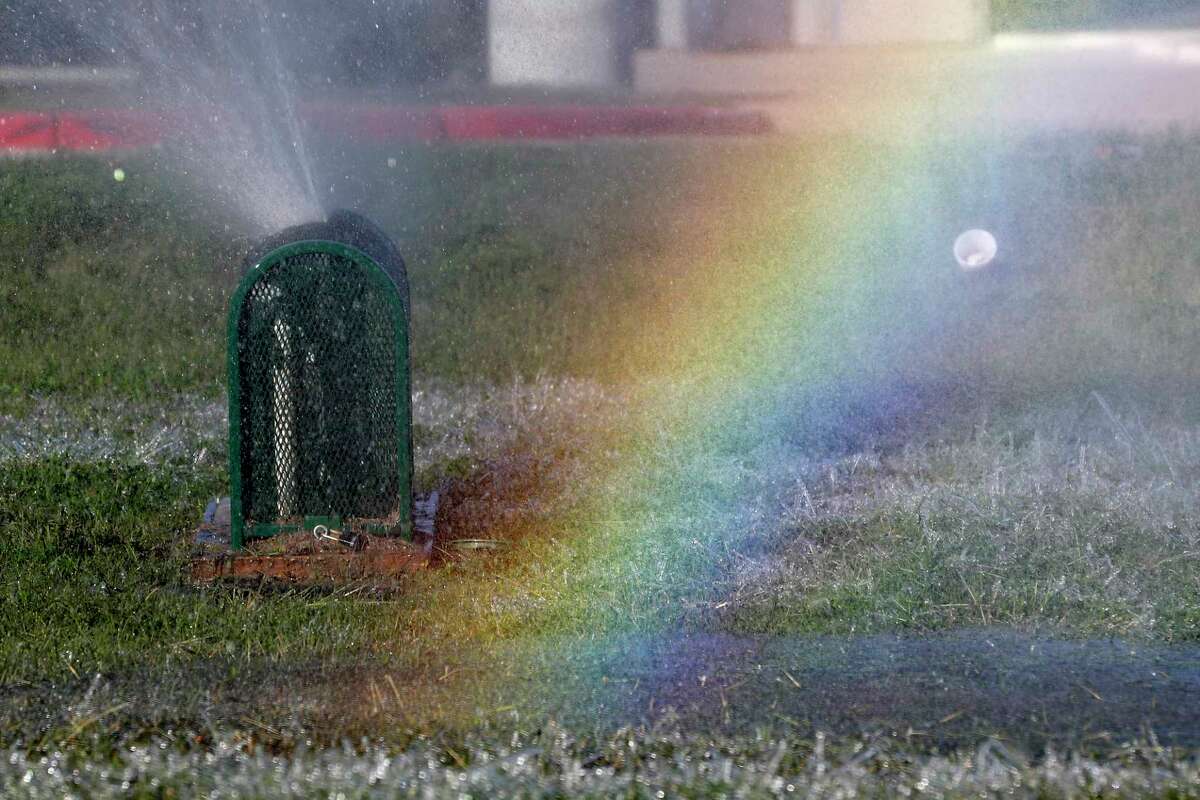 A rainbow is seen as water shoots from a main sprinkler water line that bursted along Northpark Drive after freezing temperatures, Friday, Dec. 23, 2022, in Kingwood.