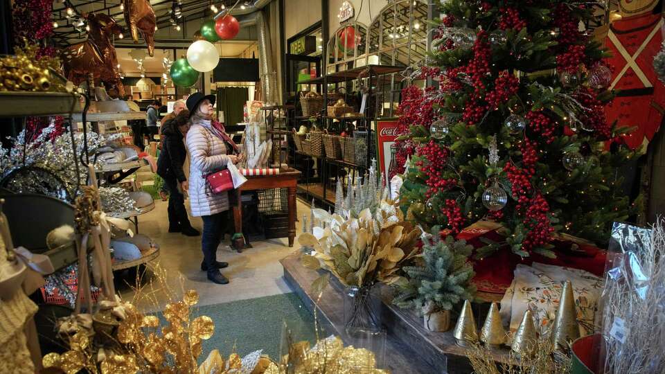 A woman looks at a Christmas display as she shops Friday, Dec. 23, 2022, at Kuhl-Linscomb in Houston.