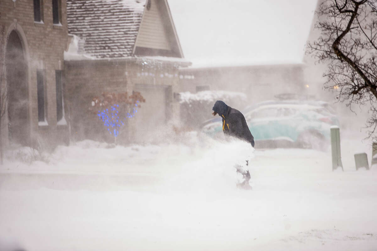 A Midland resident shovels snow through a massive wind gust on Dec. 23, 2022 on Stillmeadow Lane. Winter Storm Elliott brought about 4 inches of snow to the Midland area and wind speeds of over 31 miles per hour, according to the Weather Channel.