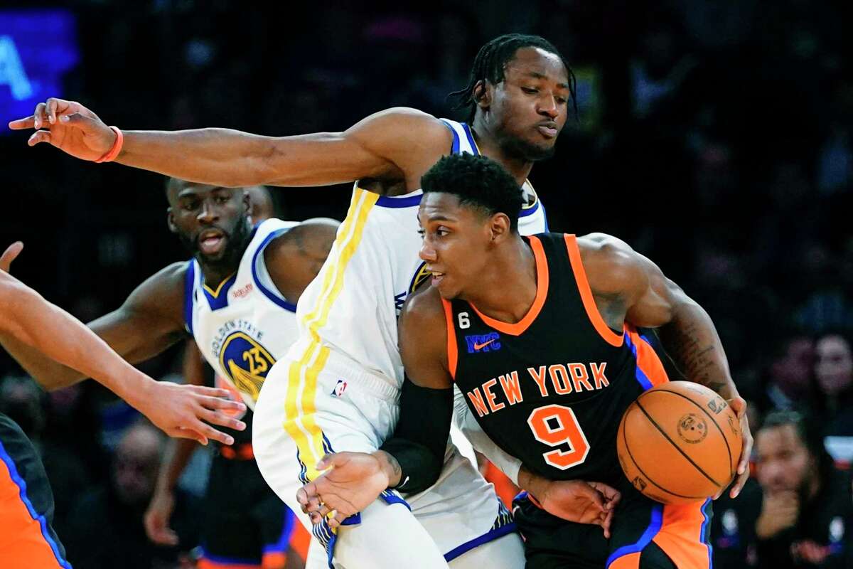 New York Knicks' RJ Barrett (9) drives past Golden State Warriors' Jonathan Kuminga (00) during the first half of an NBA basketball game Tuesday, Dec. 20, 2022, in New York. (AP Photo/Frank Franklin II)