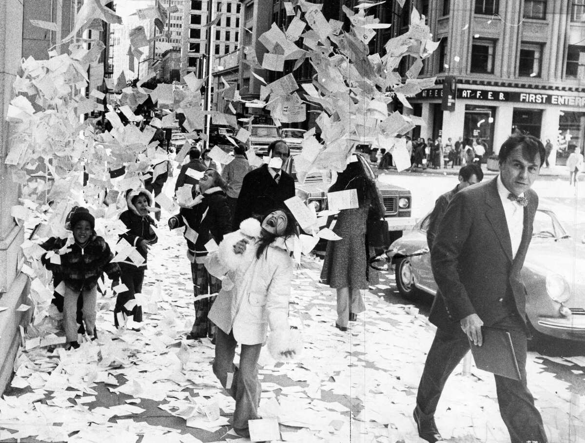 1976年12月31日，在金融区，孩子们在从高楼窗户扔出的日历页、电话留言和备忘录中玩耍。