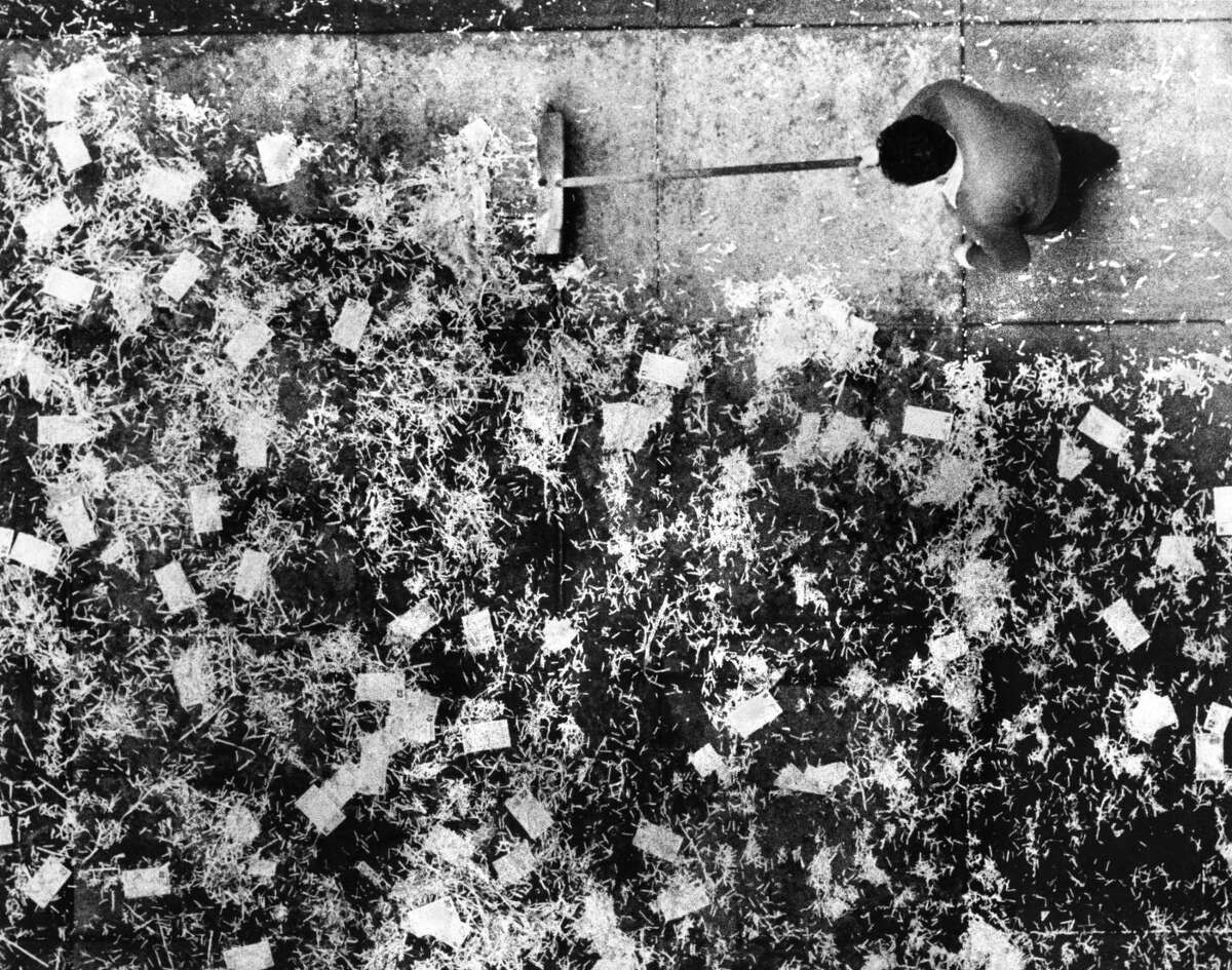A city worker clears calendar pages and other trash that was tossed out Financial District windows on the last day of 1988.