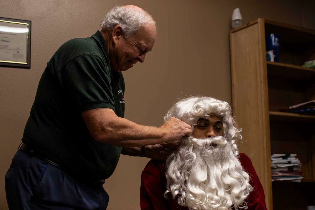 Jerry Ferguson helps Keldon Johnson get dressed as Santa Claus. Johnson’s strong ties to the West Side stem from the community being “one of the first” that supported him in his first year.