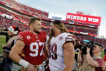 San Francisco 49ers defensive end Nick Bosa, right, hugs his father, former  player John Bosa, before an NFL football game between the 49ers and the  Tampa Bay Buccaneers in Santa Clara, Calif.