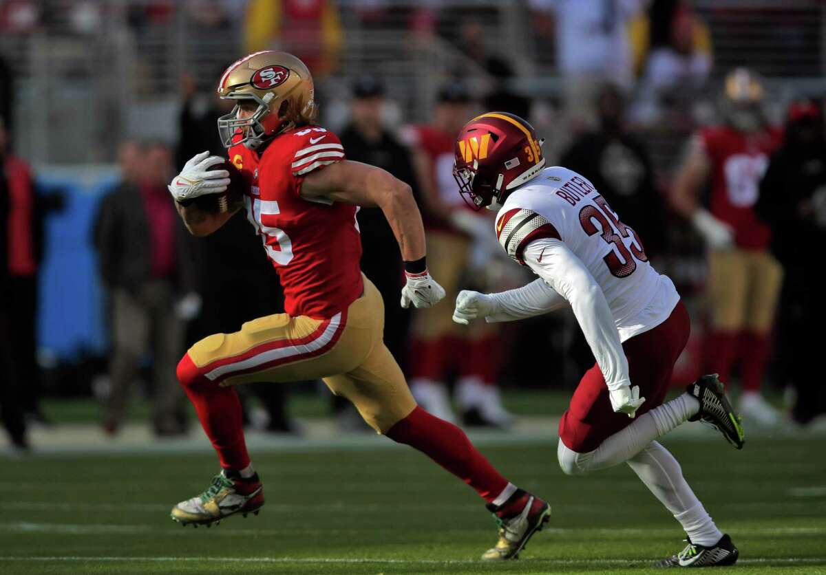 San Francisco’s George Kittle heads for a first down after a catch in the first half, pursued by Washington’s Percy Butler.