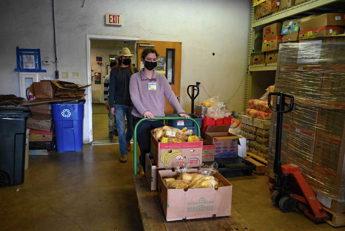 Volunteers carry food at the Hayes County Food Bank in San Marcos on Thursday, Dec. 22, 2022.