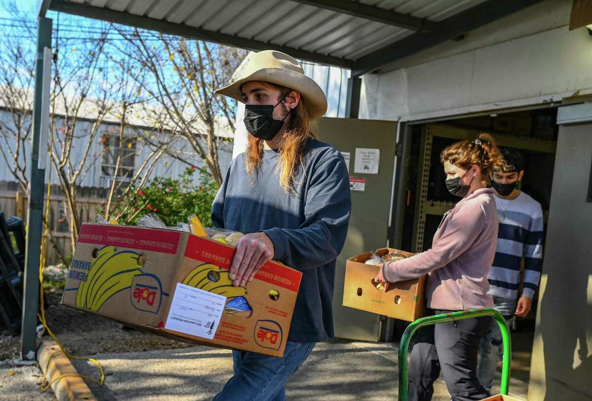 Volunteers carry supplies at the Hayes County Food Bank in San Marcos on Thursday, Dec. 22, 2022.