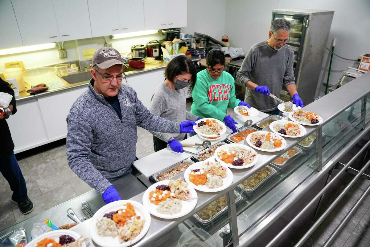 Nammie Ichilov, Laurie Lefko, Maria DeLeon and Jim Lefko plate holiday meals for homeless residents Christmas morning at Travis Park Church in partnership with Corazon Ministries.