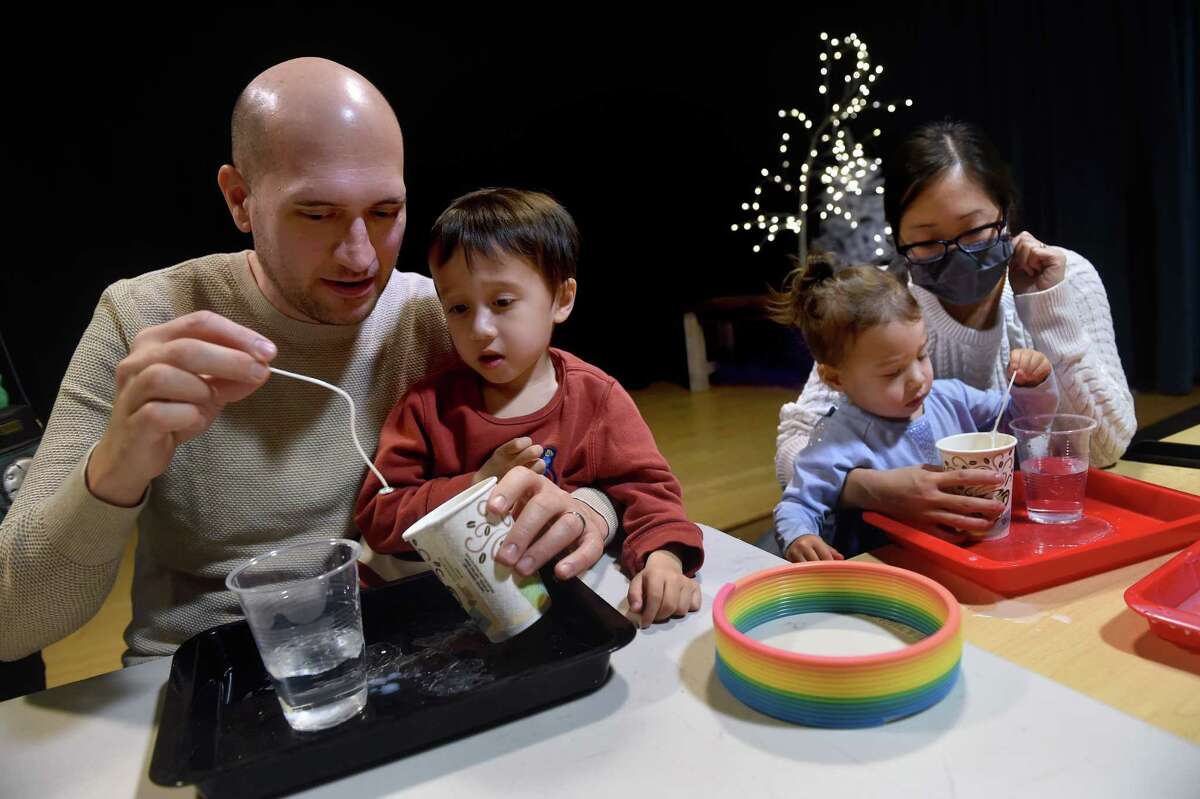 From left, Mariano Oppikofer, his son, Luca, 4, daughter, Chloe, 2, and wife, Jennifer Shum participate in Kwanzaa candle making workshop at the Stepping Stones Museum for Children in Norwalk on December 26, 2022.
