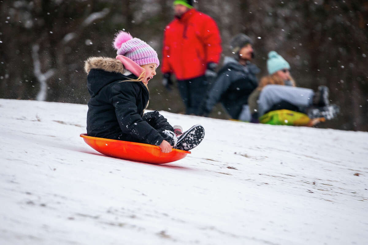 Saginaw resident Hadley Kirchner, 7, screams while sledding down a hill on Dec. 26, 2022 at Midland City Forest.