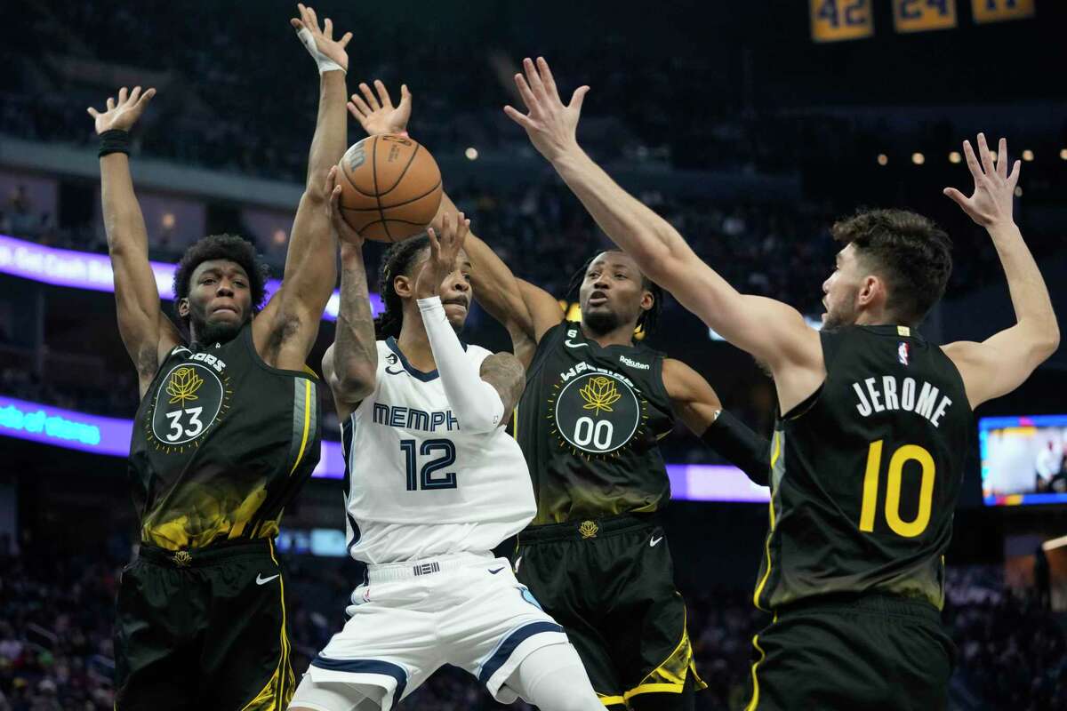 Memphis Grizzlies guard Ja Morant (12) passes the ball while defended by Golden State Warriors center James Wiseman, from left, forward Jonathan Kuminga and guard Ty Jerome during the second half of an NBA basketball game in San Francisco, Sunday, Dec. 25, 2022. (AP Photo/Godofredo A. Vásquez)