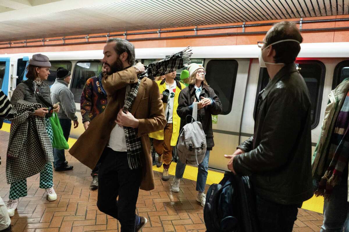 Participants exit a train to position themselves at a prime viewing spot during the BART Basel 2022 event in San Francisco on Dec. 3, 2022. The regional transit authority has announced expanded hours for New Year’s Eve.