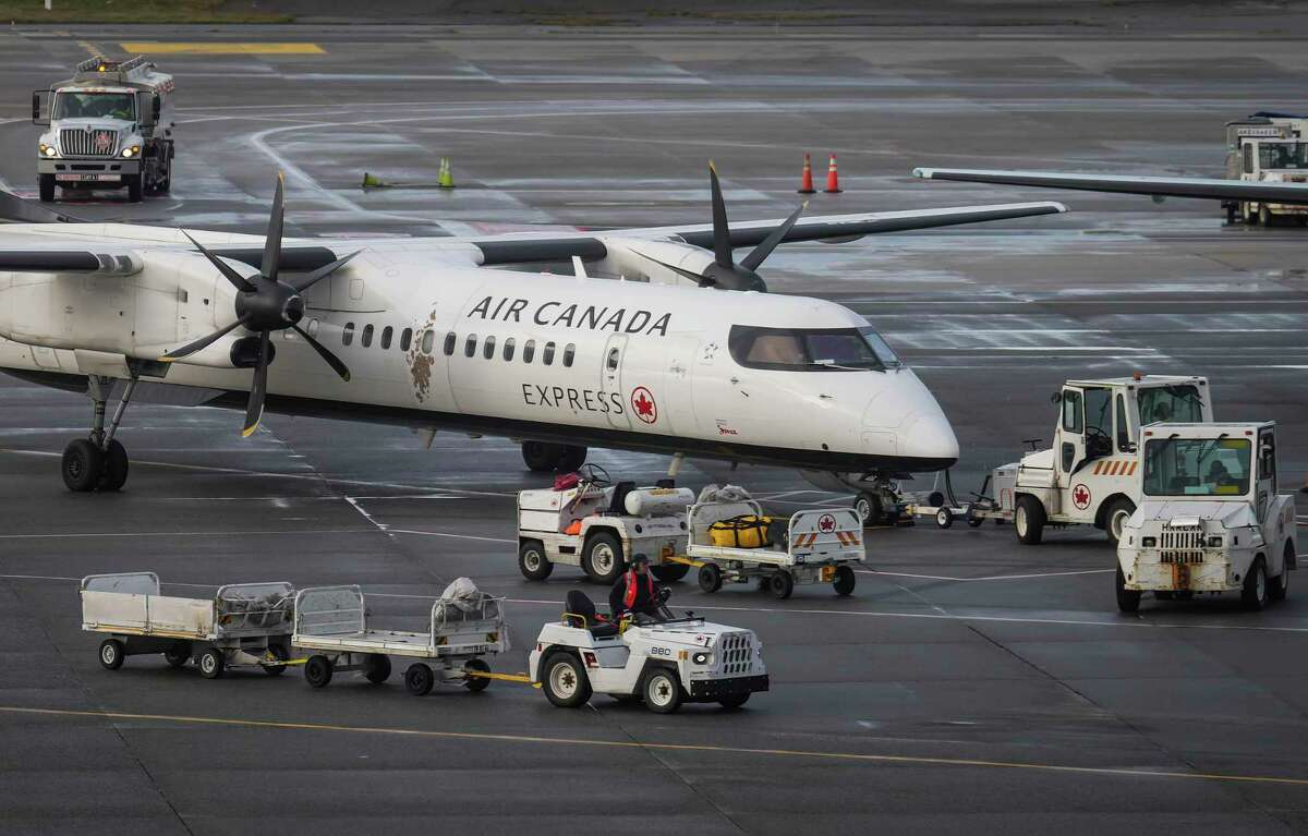 A worker drives past an Air Canada aircraft at Vancouver International Airport after operations returned to normal after last week's snowstorm in Richmond, British Columbia, Monday, Dec. 26, 2022. (Darryl Dyck/The Canadian Press via AP)