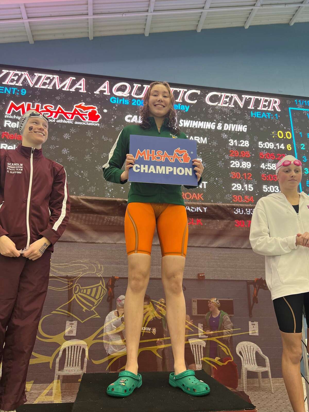 Dow High's Ella Roberson poses with the championship plaque after winning the 100-yard freestyle at the Division 2 state finals on Nov. 19, 2022.