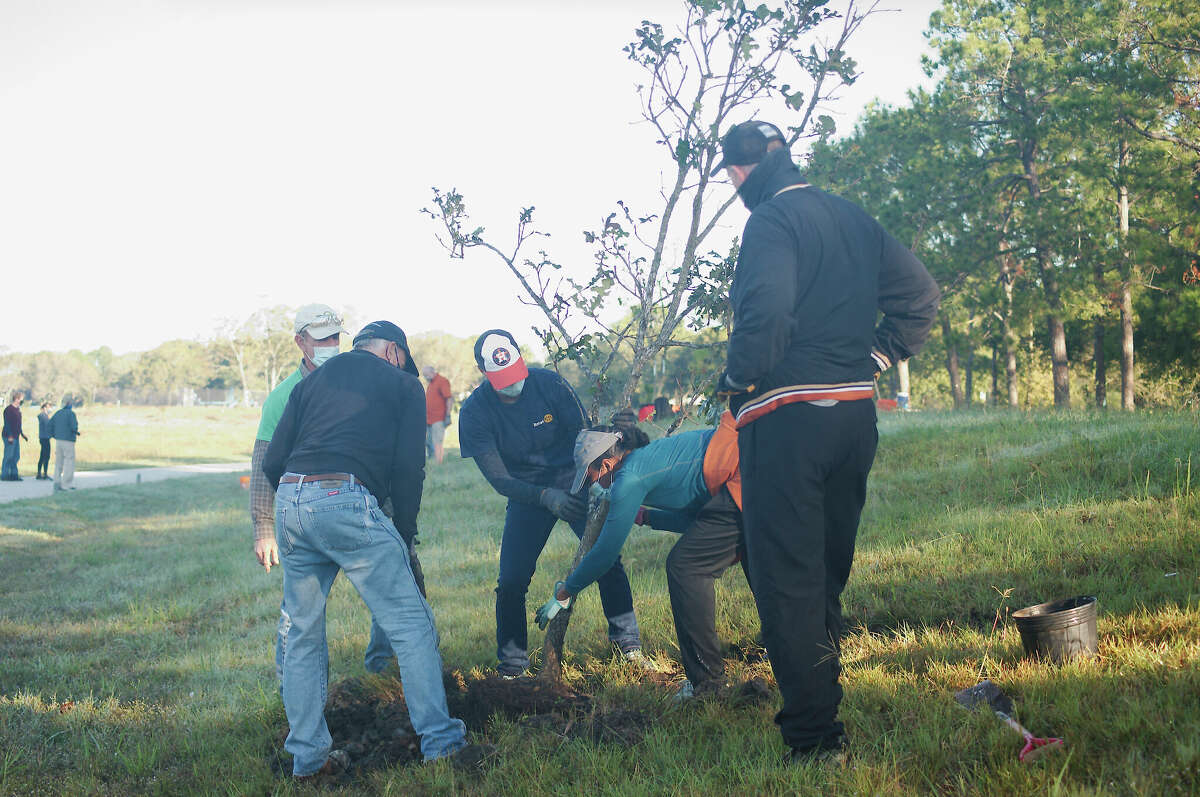 Chatt Smith, Greg Blackburn and Brian Stevens watch as Melinda Mintz and Sheela Logan plant a tree at Exploration Green in 2020. The park is planning another tree-planting event for Jan. 21.