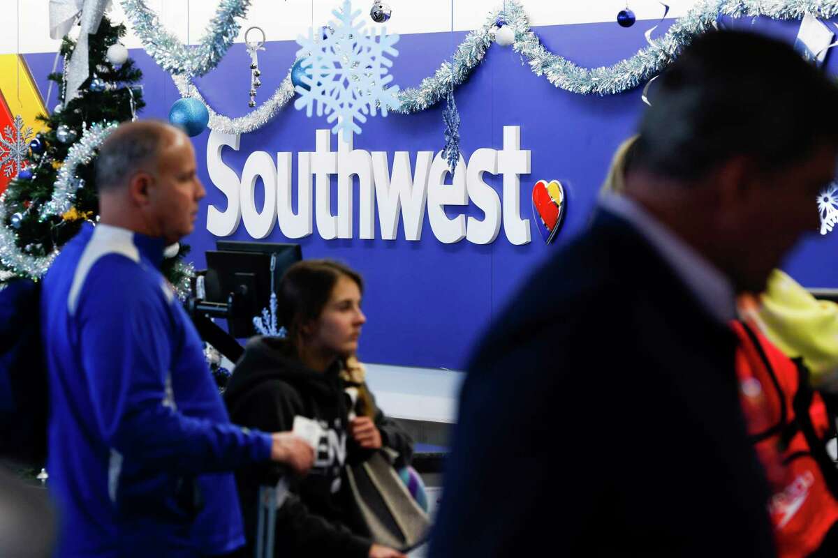 Travelers stand in line to try and find new flights after almost all of Southwest Airlines flights were canceled at Oakland International Airport on Tuesday, Dec. 27, 2022.