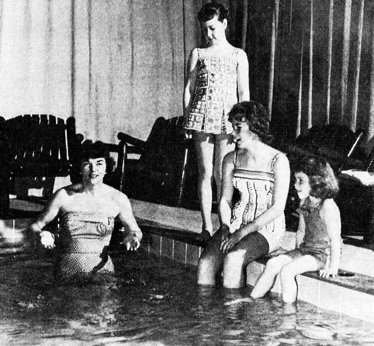 "Swim-testing" new Bill Atkinson swimwear and at the same time modeling for forthcoming publicity on the Glen of Michigan line are four models enjoying their work at the newly completed Hotel Chippewa swimming pool. Among the first people to take the plunge in suits created by well-known Glen ,of Michigan, designer was Pat Cummings, Atkinson's assistant (standing left) in the pool. Local models considering a dip are Cindy Freed (standing); Mary Ann Anderson and Susie Howe. The photo was published in the News Advocate on Dec. 31, 1962.