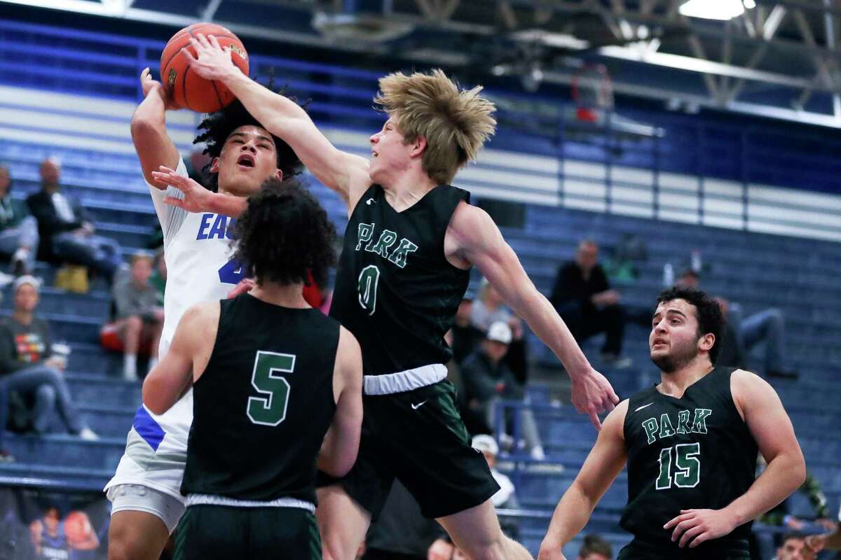 New Caney guard Dylan Dempsey (4) gets his shot blocked by Kingwood Park guard Trent Burningham (0) during a high school basketball game at the BSN Sports New Caney ISD Basketball Tournament, Tuesday, Dec. 27, 2022, in New Caney.