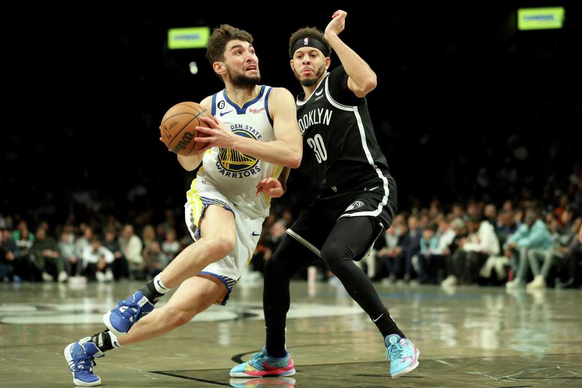 Ty Jerome #10 of the Golden State Warriors drives to the basket against Seth Curry #30 of the Brooklyn Nets during the second half of the game at Barclays Center on December 21, 2022 in Brooklyn.