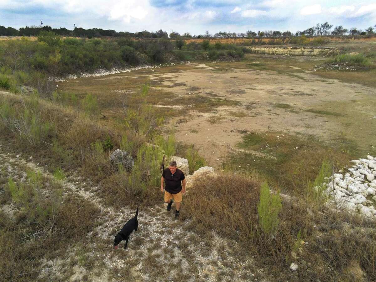 David Prickett and his dog, Silhouette, enjoy an old quarry that has been returned to a natural state at the Cibolo Gardens Nature Preserve and Event Center Thursday, Dec. 8, 2022.
