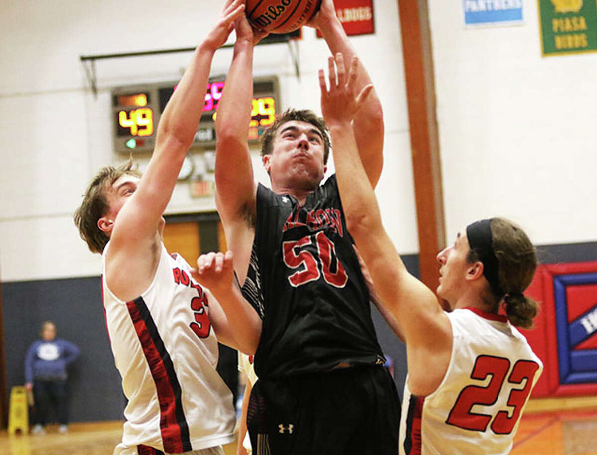 Calhoun's Conner Longnecker (middle) puts up a shot in the lane over Staunton's Braden Buffington (23) and Brady Gillen in a pool game Monday at the Carlinville Tourney. On Tuesday, Longnecker had 13 points in the Warriors' OT loss to top-seeded Litchfield.