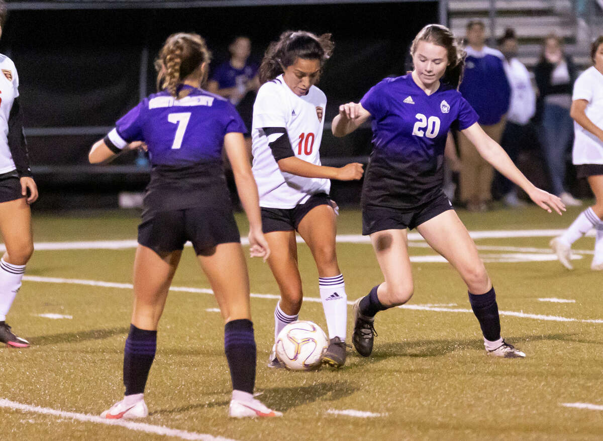 Caney Creek Julie Mendoza (10) drives the ball while under pressure from Montgomery defensive midfielder Makenzie Griffith (7) and forward Ashlee Stoltje (20) during the first period of a District 20-5A girls high school soccer match at Montgomery High School, Tuesday, Jan. 26, 2021, in Montgomery.