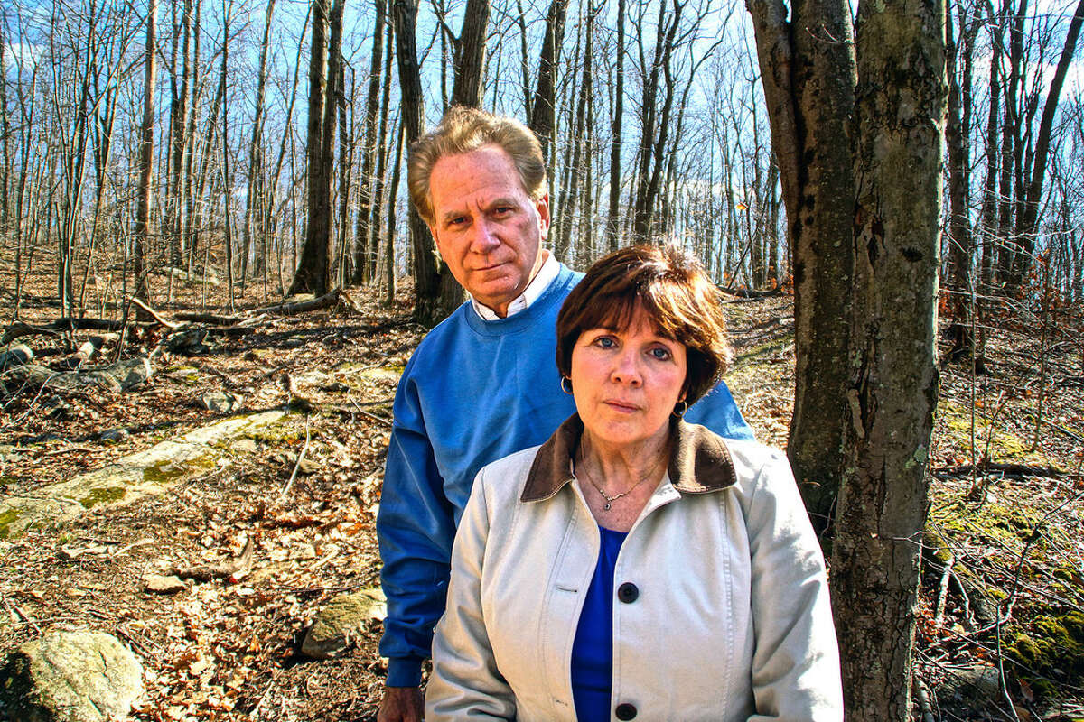 File photo from 2012 shows Jan and Bill Smolinski Sr. in a wooded area in Shelton during their ongoing search for Billy Smolinski Jr., who has been missing since 2004. The Smolinskis' unrelenting search for their son and the problems they ran into inspired Billy's Law, which President Biden signed Tuesday.