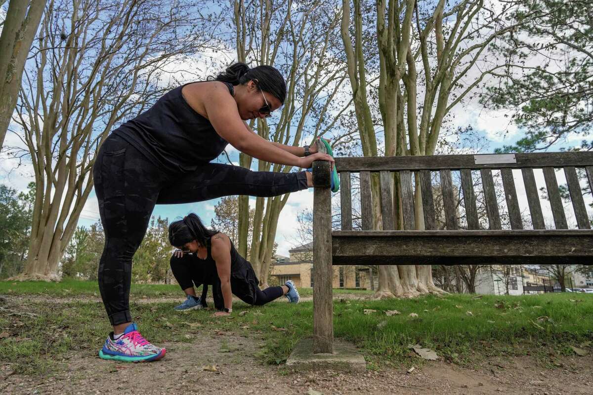 Twins Liah Martinez and Lauryn Chavez, 26, stretch as they pursue fitness journeys after having had gastric sleeve surgery about four years ago on Wednesday, Dec. 28, 2022 in Houston.