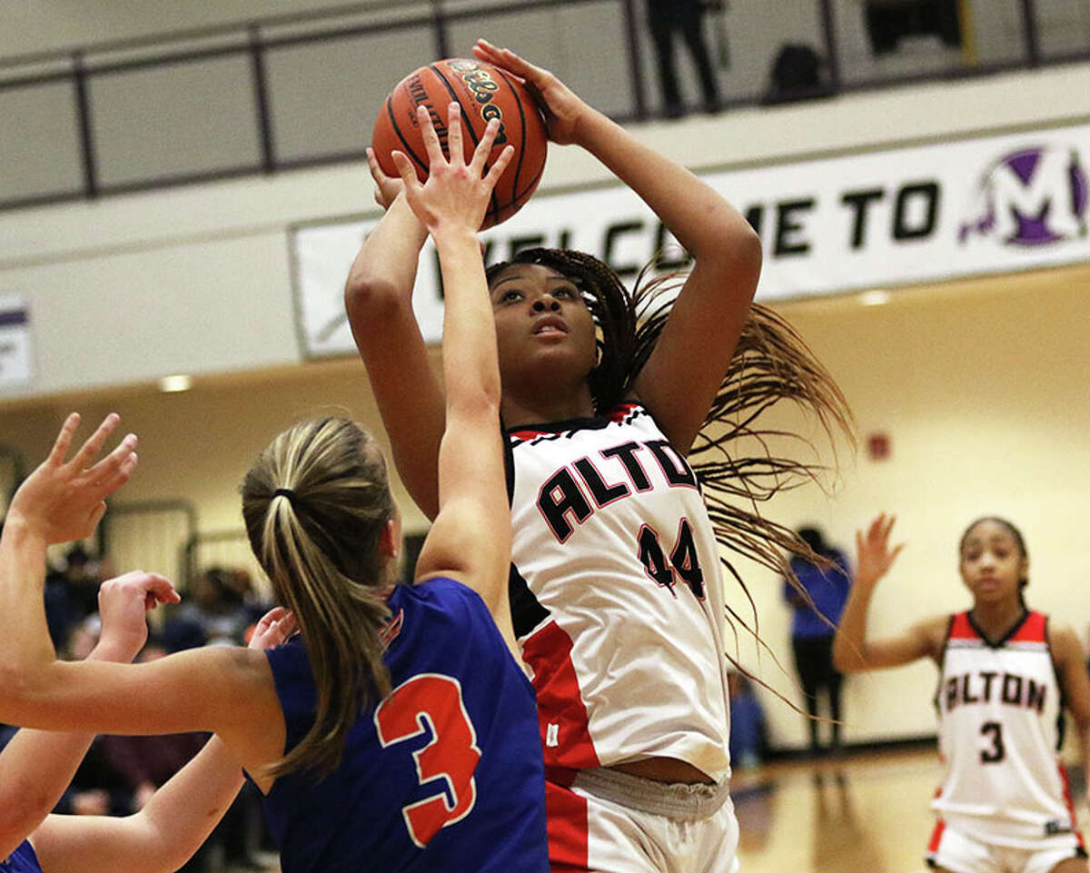Alton's Jarius Powers scores two of her 22 points over Okawville's Megan Rennegarbe (3) on Wednesday night in the semifinals of the Mascoutah Tournament.