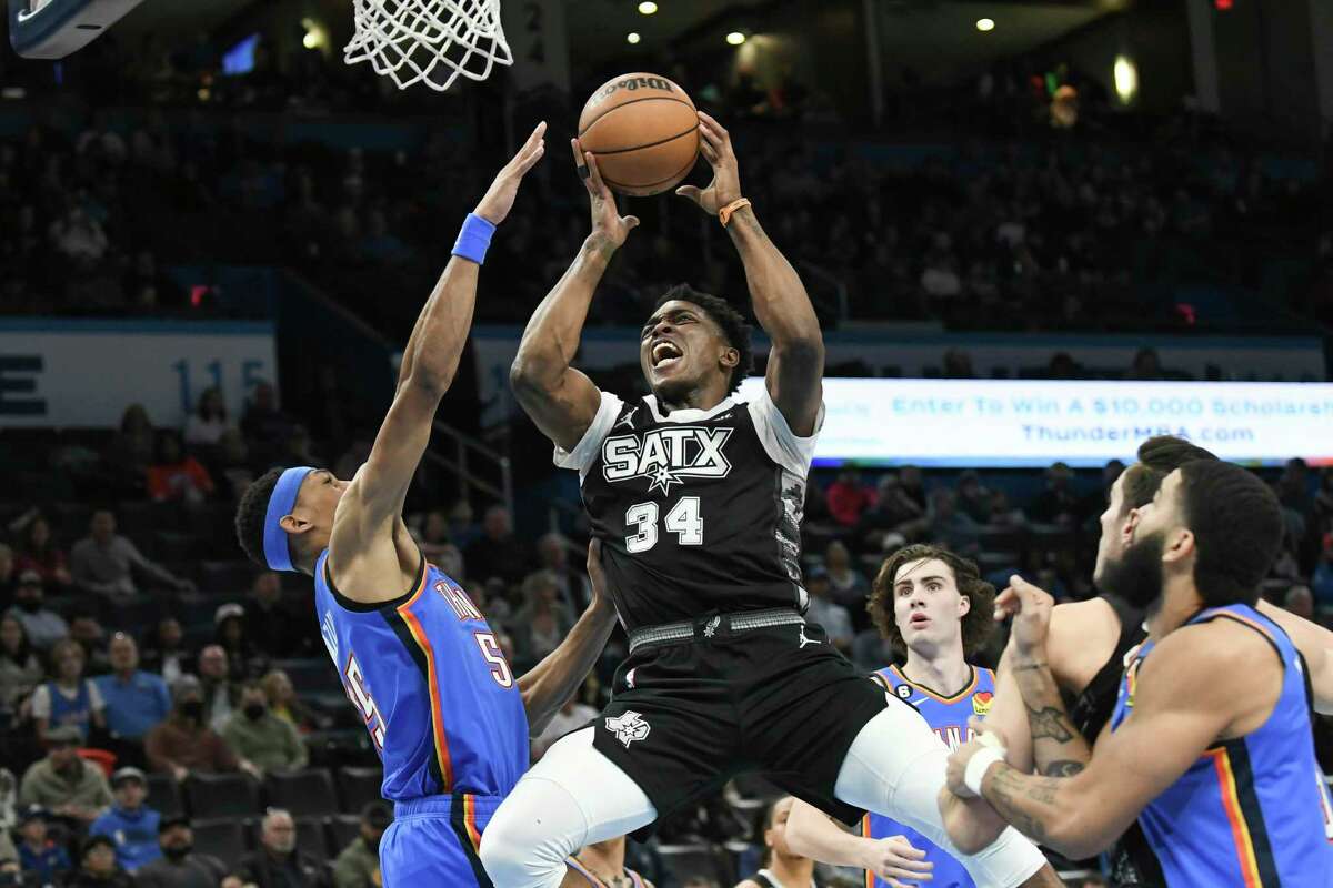 San Antonio Spurs forward Stanley Johnson (34) goes up for a shot over Oklahoma City Thunder forward Darius Bazley (55) in the first half of an NBA basketball game, Tuesday, Dec. 27, 2022, in Oklahoma City. (AP Photo/Kyle Phillips)
