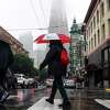 Rain falls on pedestrians on Pacific Avenue in San Francisco’s North Beach.