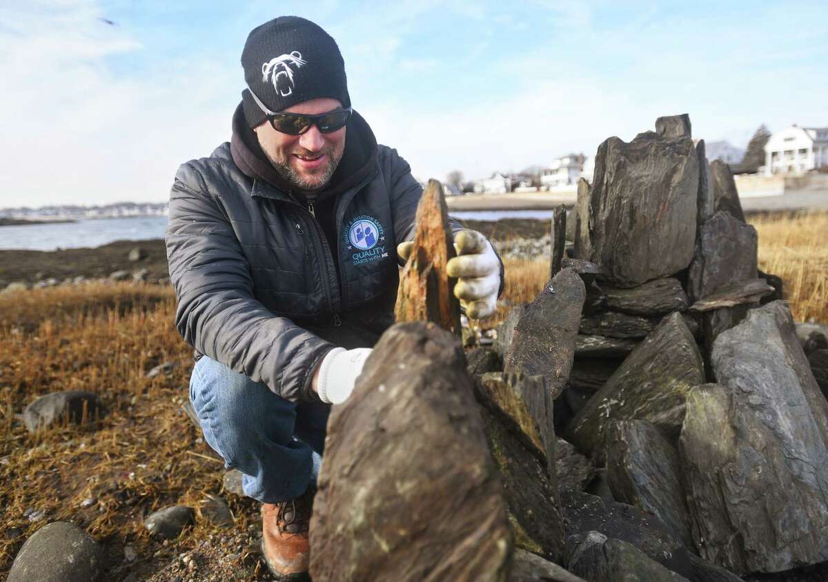 Steve Warzel builds short lived rock sculptures, demolished as the high tide rolls in, at Anchor Beach in Milford, Conn. on Thursday, December 29, 2022.
