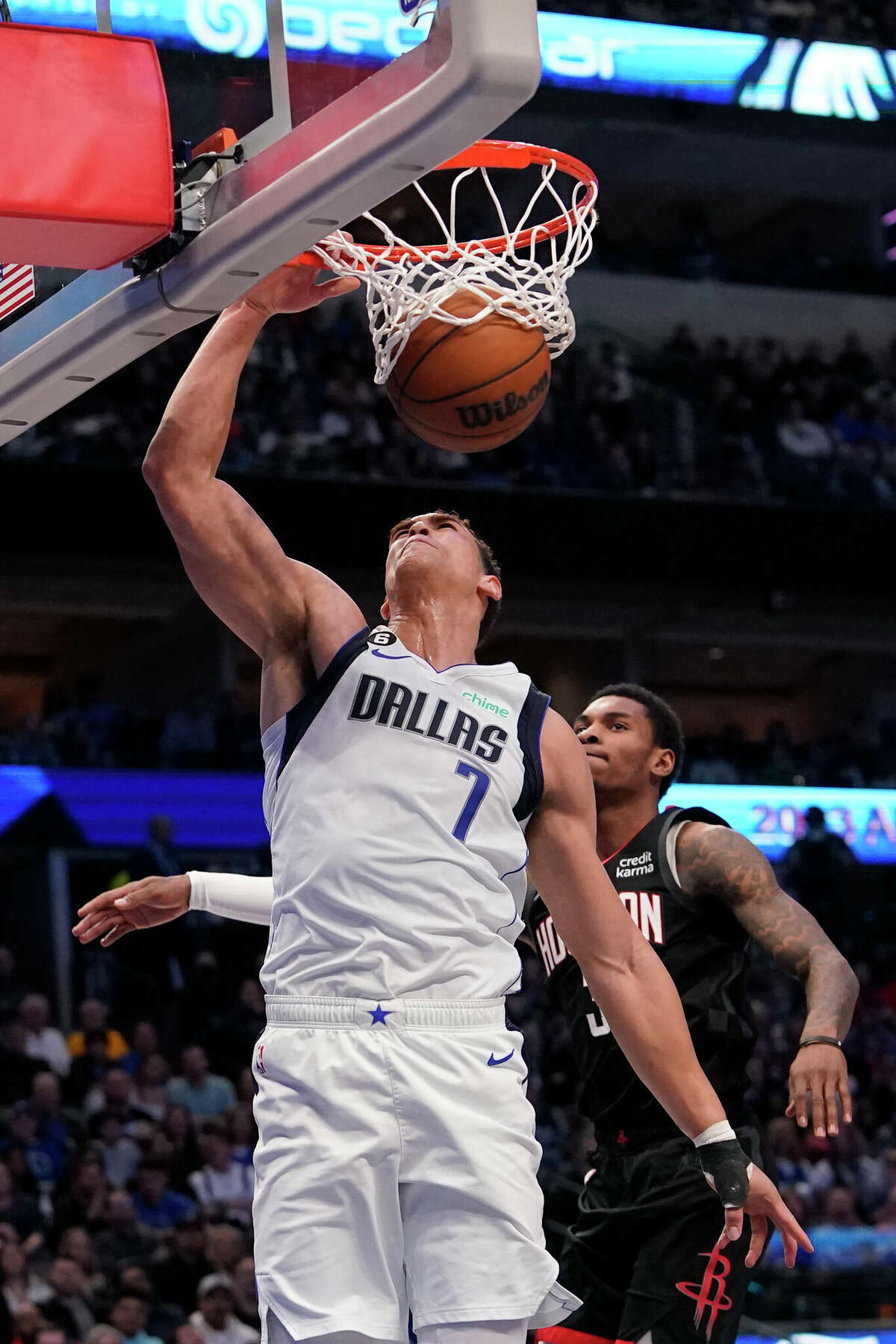 Dallas Mavericks center Dwight Powell (7) scores a basket against Houston Rockets guard Kevin Porter Jr. (3) during the first half of an NBA basketball game in Dallas, Thursday, Dec. 29, 2022. (AP Photo/LM Otero)