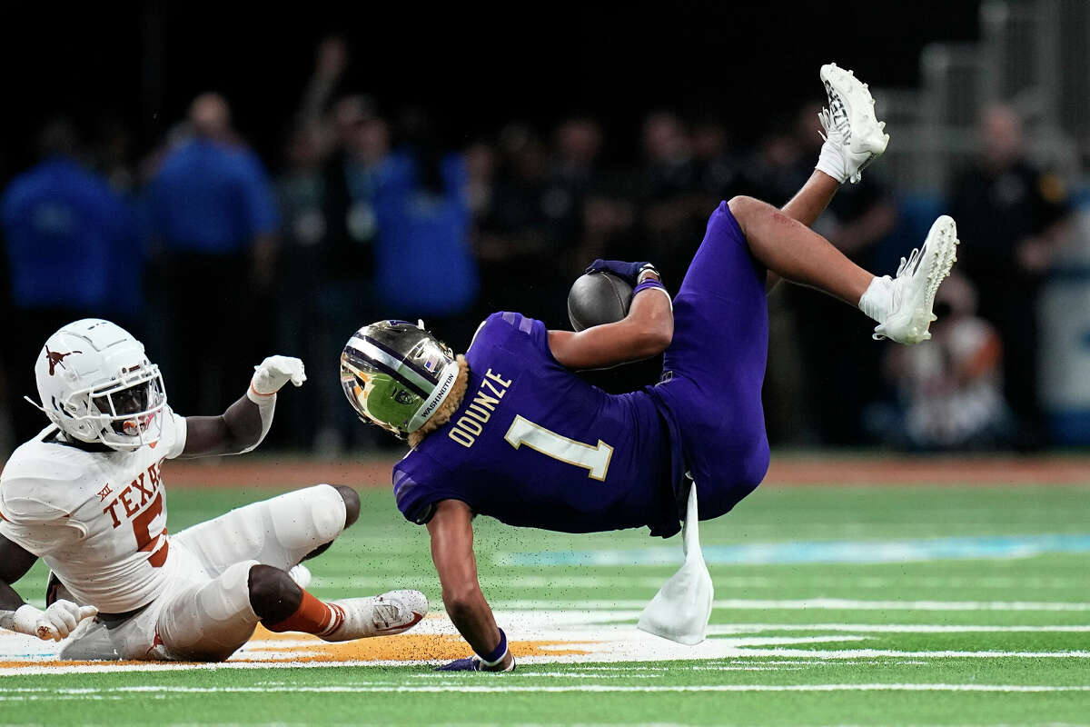 Washington wide receiver Rome Odunze (1) is upended by Texas defensive back D'Shawn Jamison (5) after making a catch during the second half of the Alamo Bowl NCAA college football game in San Antonio, Thursday, Dec. 29, 2022. (AP Photo/Eric Gay)