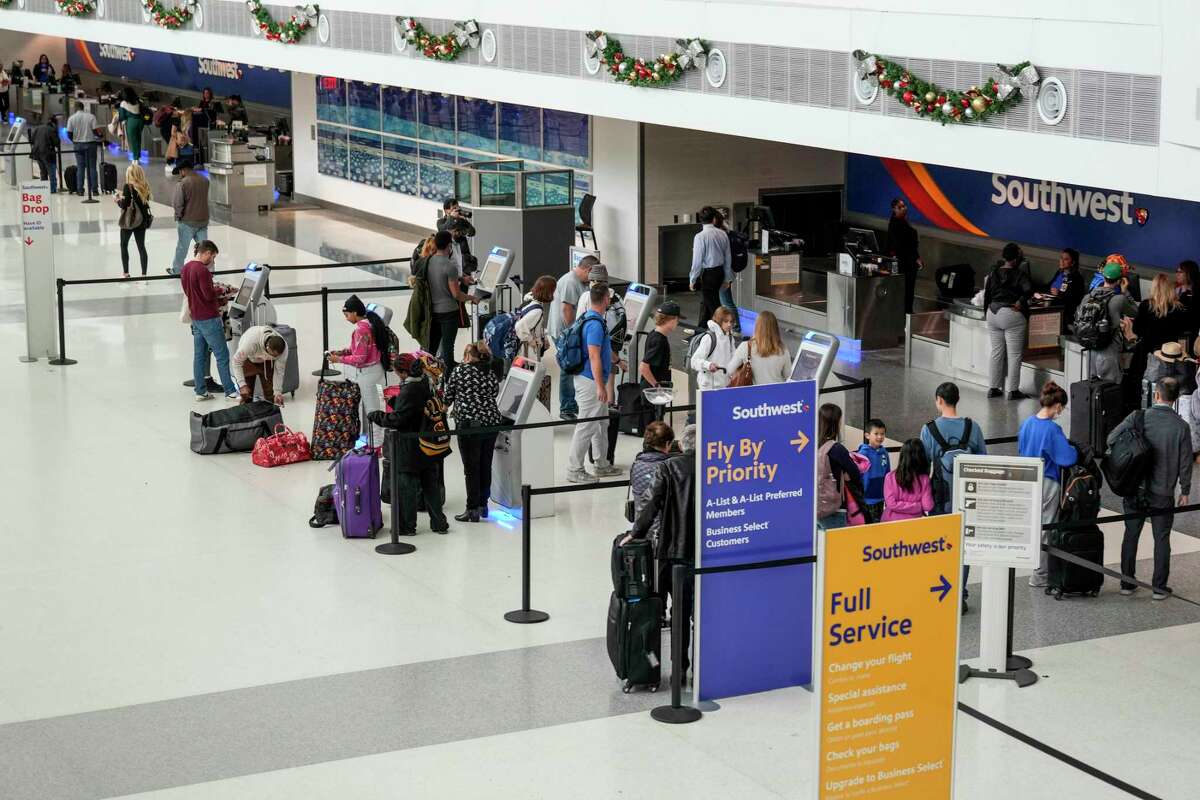 Passengers check in for their flights at the Southwest Airlines ticket counters at Hobby Airport for their flights on Friday, Dec. 30, 2022 in Houston. Southwest Airlines plans to return to its regular schedule starting Friday, officials announced Thursday, even through airline had canceled another 133 flights into and out of Houston’s Hobby Airport, according to FlightAware, a flight tracking website. The airline was running about a third of its usual flights as of Thursday, the latest in several days full of cancelations and chaos for the company.