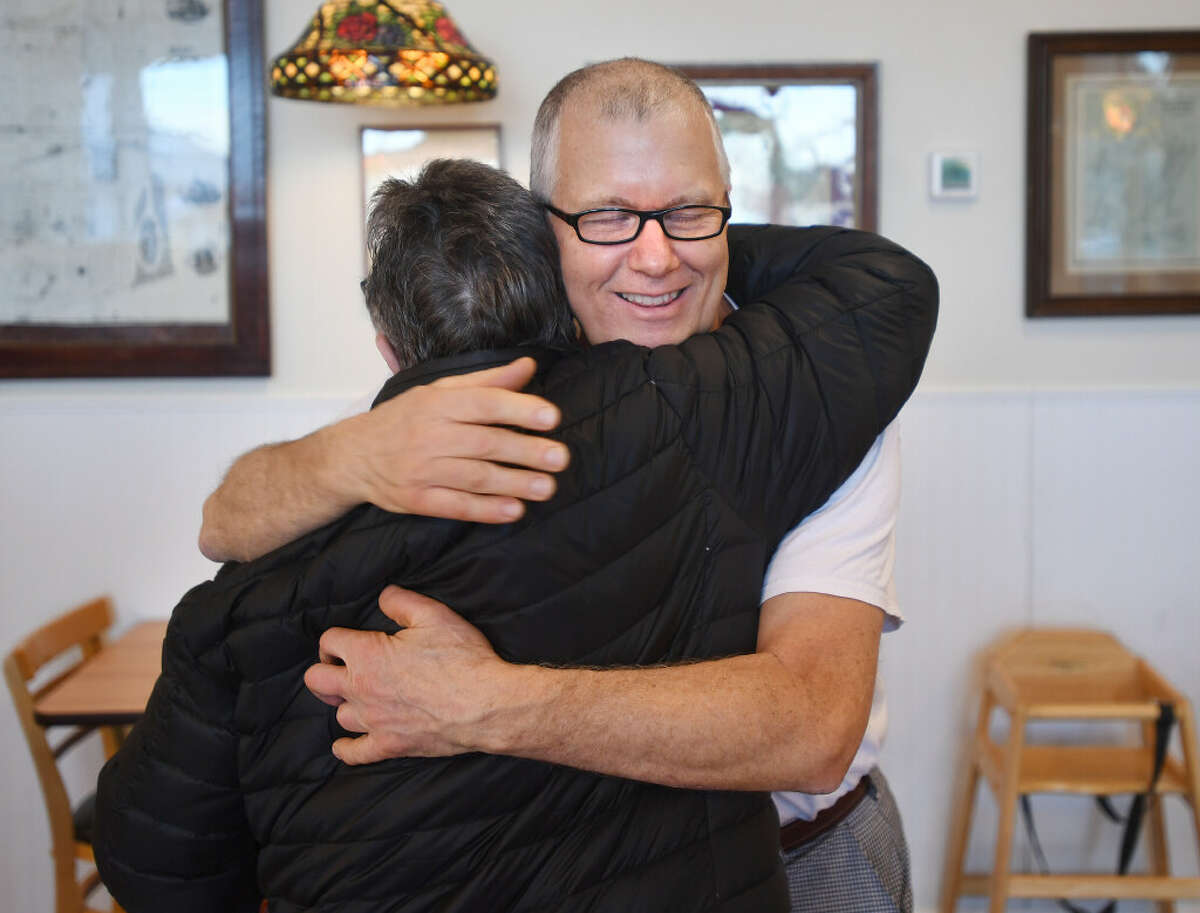 Julia's Bakery owner Jeffrey Chandler shares hugs with a longtime customer in the bakery's final week Dec. 29.