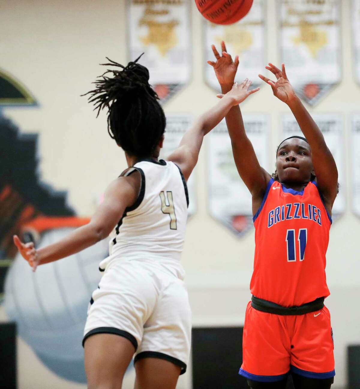 Grand Oaks' Bree Riley (11) shoots over Conroe's Alana Harris (4) during the second quarter of a District 13-6A high school basketball game at Conroe High School, Friday, Dec. 30, 2022, in Conroe.