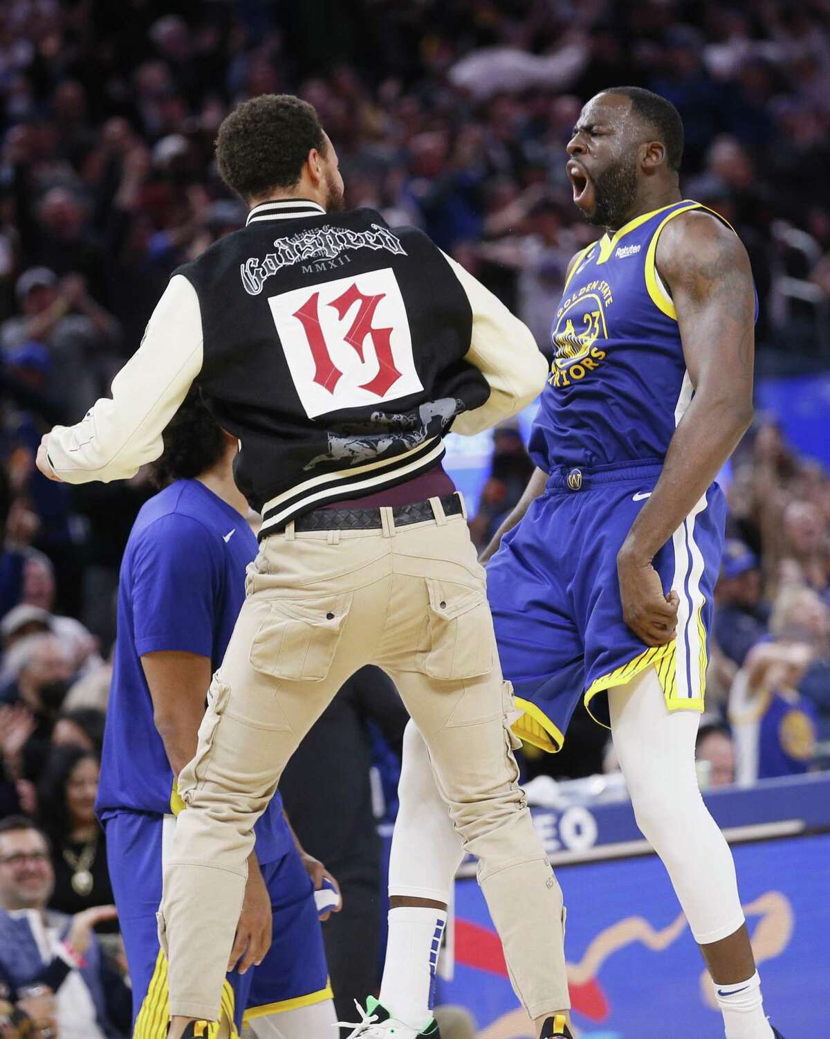 Golden State Warriors forward Draymond Green (23) and Warriors guard Stephen Curry celebrate against the Portland Trail Blazers during a timeout late in the fourth quarter of an NBA game at Chase Center in San Francisco, Calif., Friday, Dec. 30, 2022. The Warriors won 118-112.