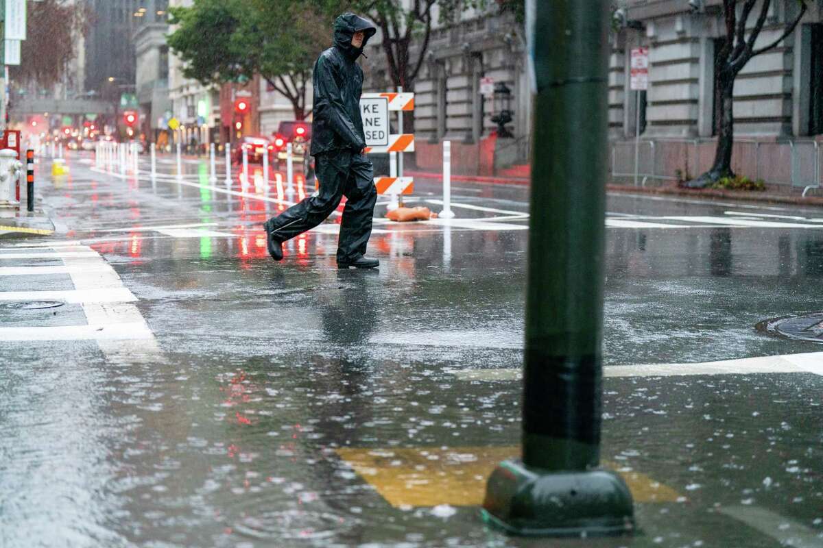 A pedestrian avoids a ample  puddle on  Battery Street successful  the Financial District of San Francisco connected  Saturday, Dec. 31, 2022.