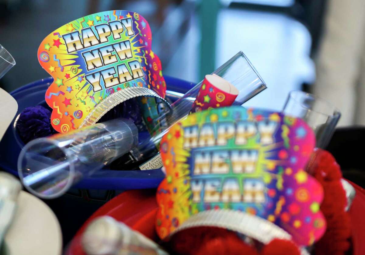 New Year’s-themed plastic hats are seen filled with party favors, glasses and small bottles of champagne for guests at Margaritaville Lake Conroe on New Year’s Eve, Saturday, Dec. 31, 2022, in Montgomery.