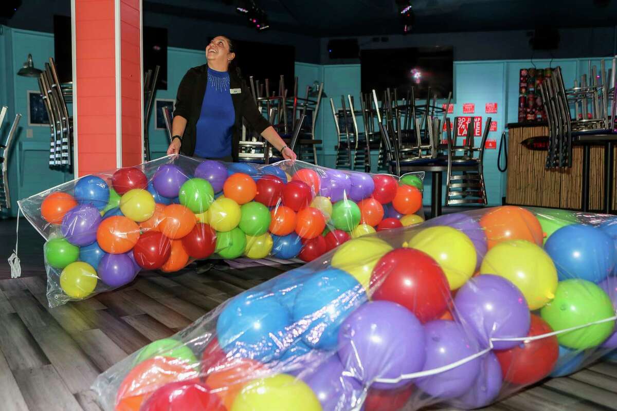 Erika DelaCruz looks for where to hang bags filled with balloons for a midnight balloon drop for guests at Margaritaville Lake Conroe on New Year’s Eve, Saturday, Dec. 31, 2022, in Montgomery. Guests enjoyed live entertainment, including fire dancers, live music and a balloon drop at midnight along with a four-course New Year’s Eve dinner.