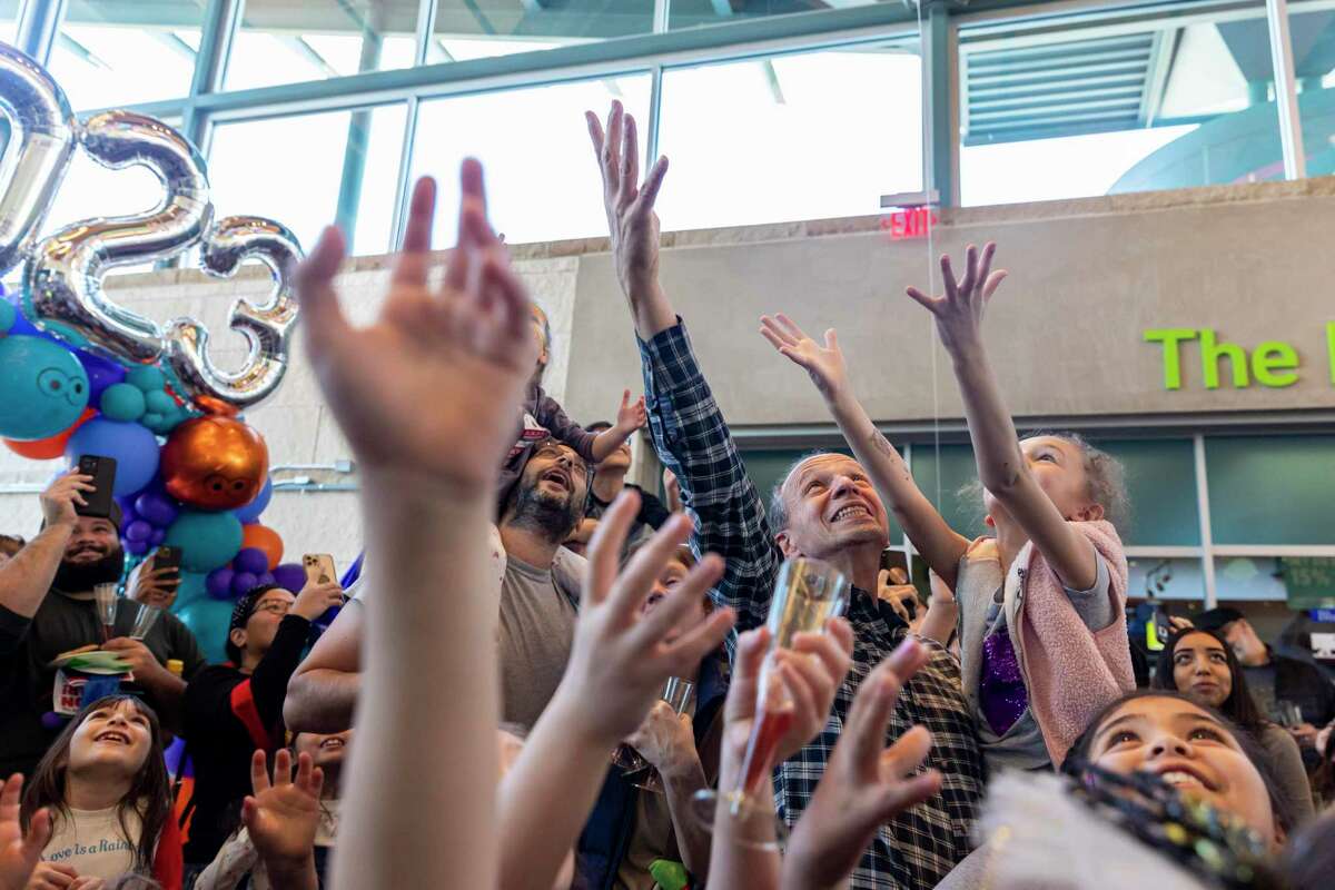 Attendees excitedly reach for the falling balloons during the annual children’s “Noon Year” event on Saturday, Dec. 31, 2022, at the Doseum in San Antonio.
