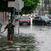 2022年12月31日星期六，加利福尼亚州旧金山，人们试图疏通雨水排水沟，以帮助缓解第14街的洪水。