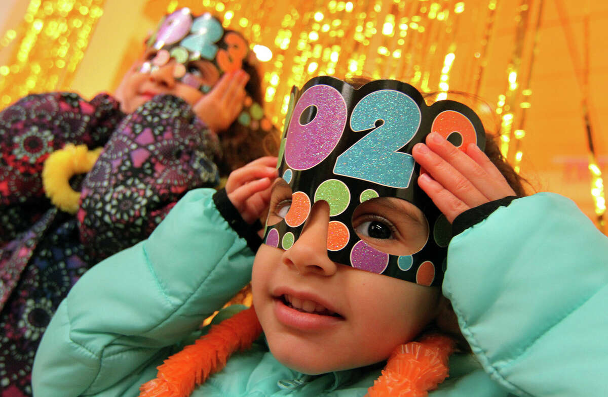 Lily Rogriguez, 3, dons a 2023 mask as she joins with other kids ringing in the New Year with a dance party and other fun activities inside the Marx Family Black Box Theater at Greenwich Library in Greenwich, Conn., on Saturday December 31, 2022.