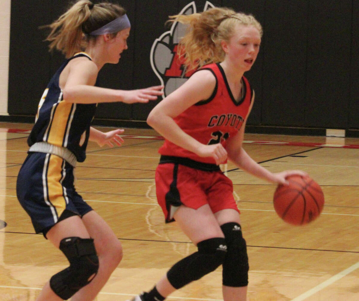 Reed City's Morgan Hammond (right) goes to the basket against Ithaca's defense in Saturday's game.