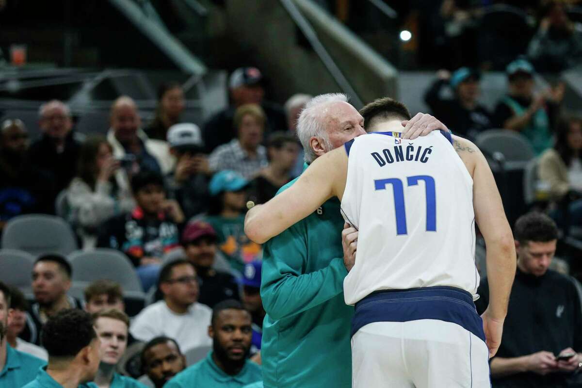 Spurs head coach Gregg Popovich talks to Mavericks guard Luka Doncic (77) before Saturday’s game at AT&T Center.