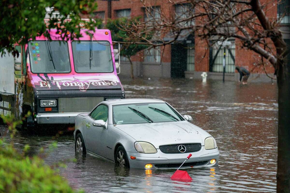 Cars sit in flooded water on 14th Street in the Mission District in San Francisco on Dec. 31.