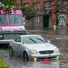 Cars sit in flooded water on 14th Street in the Mission District in San Francisco.
