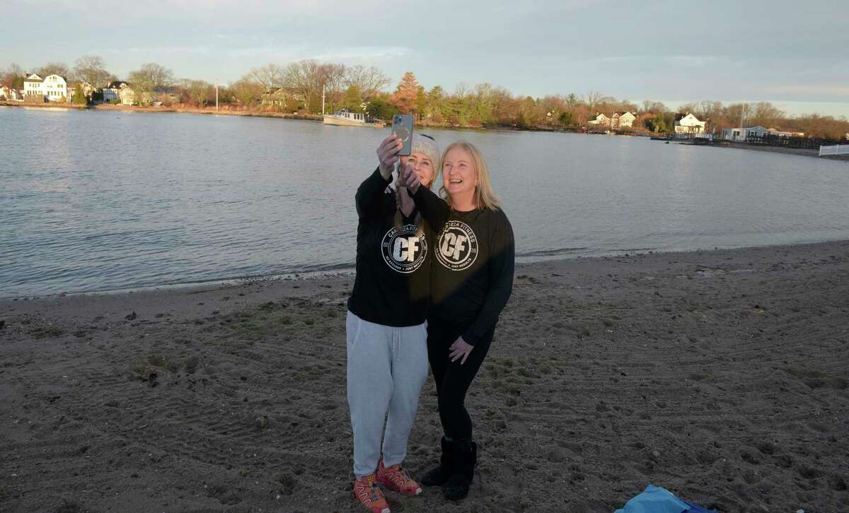 Carolyn Samuel, of Greenwich, right, and Victoria Marsh, of Stamford, take a photo before participating in a polar plunge at Pear Tree Point Beach. The plunge, organized by Carozza Fitness owner Michael Carozza, benefited Animals R Us. Sunday, January 1, 2023, Darien, Conn.